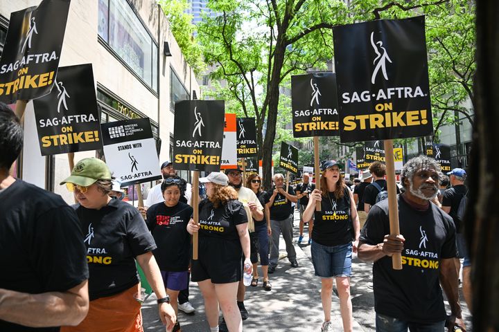 Members of the Writers Guild of America East and SAG-AFTRA walk the picket line outside NBC Rockefeller Center on July 14, 2023 in New York City. 
