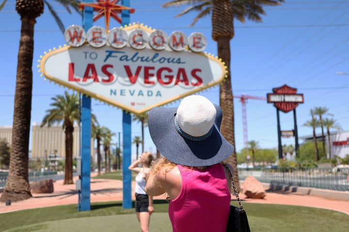 A woman takes a photo in front of the Welcome to Las Vegas Sign during a heat wave in Las Vegas, Nevada, on July 14, 2023. 