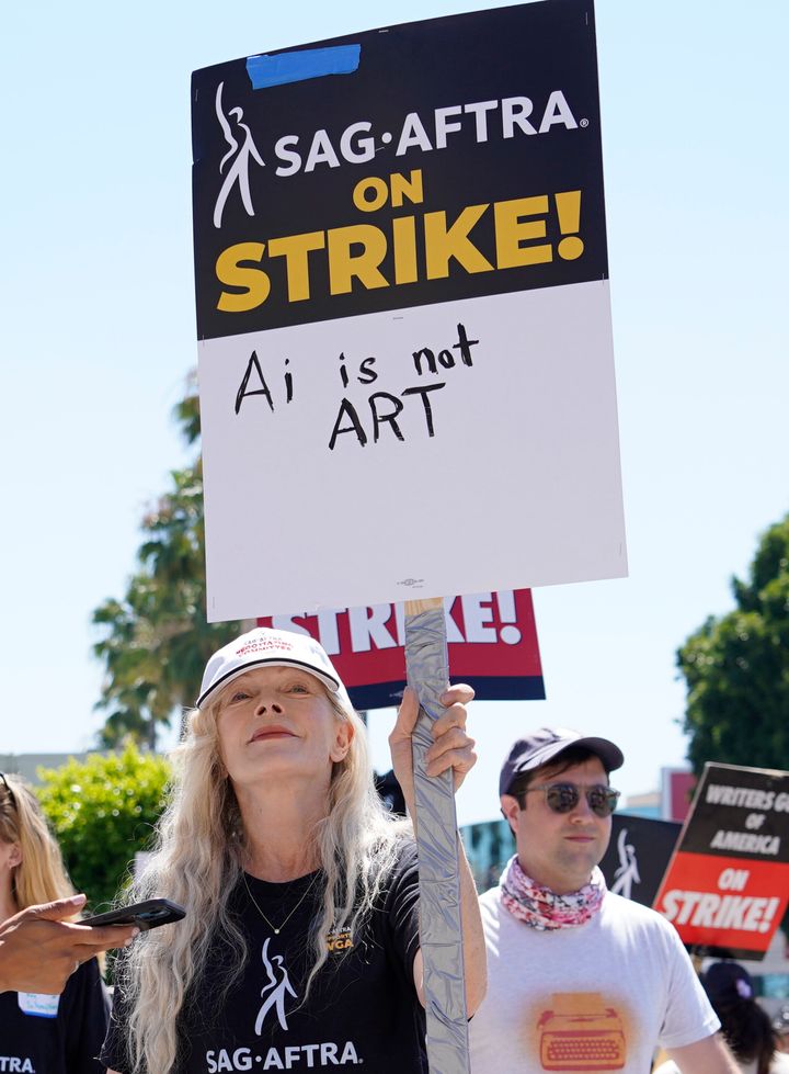 Actor Frances Fisher holds a sign that says "AI is not art" at a rally outside Paramount studios. 