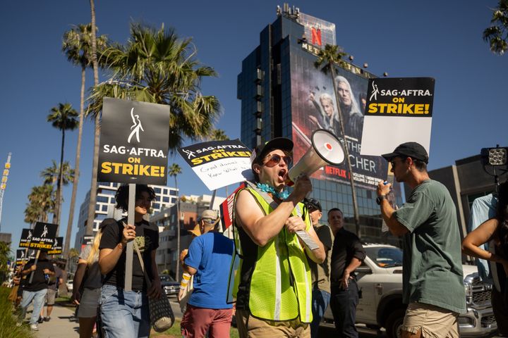 SAG-AFTRA and WGA members walk the picket line outside Sunset Bronson Studios, home of Netflix, on Friday in Los Angeles.