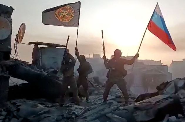 ウクライナ東部バフムトとされる場所でロシア国旗を掲げる民間軍事会社「ワグネル」戦闘員＝通信アプリに2023年5月20日に投稿された動画より