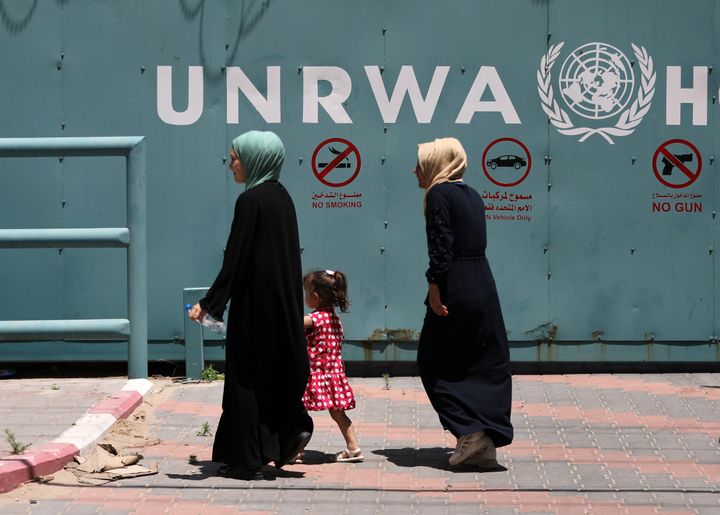 Palestinian women walk in front of the headquarters of the United Nations Relief and Works Agency (UNRWA) during a protest against the reduction in food aid distribution on June 20, 2023.