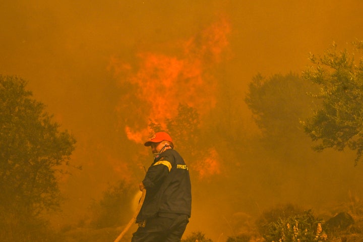 A fireman stands in front of the blazes of a fire in New Peramos, near Athens, on July 19, 2023.