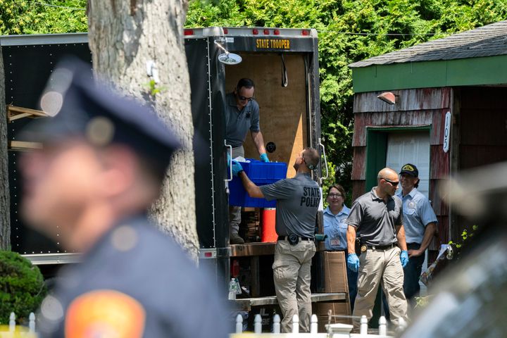 New York State police officers place items into the back of a truck during a search Saturday at the home of Rex Heuermann in Massapequa Park, New York. Heuermann, a Long Island architect, was charged Friday in the case known as the Gilgo Beach murders.