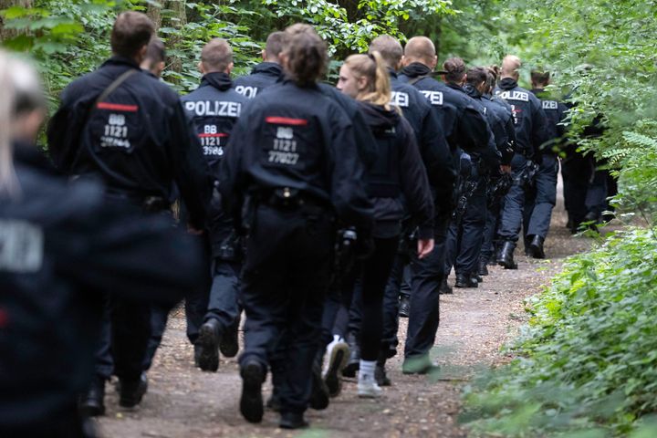 Police officers walk in a forest during the second day of efforts to capture what authorities believe to be an escaped lioness near Berlin on July 21, 2023.