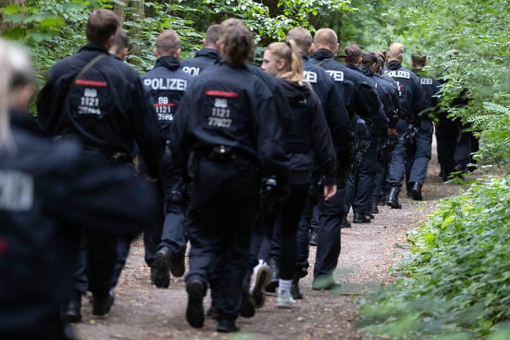 Police officers walk in a forest during the second day of efforts to capture what authorities believe to be an escaped lioness near Berlin on July 21, 2023.