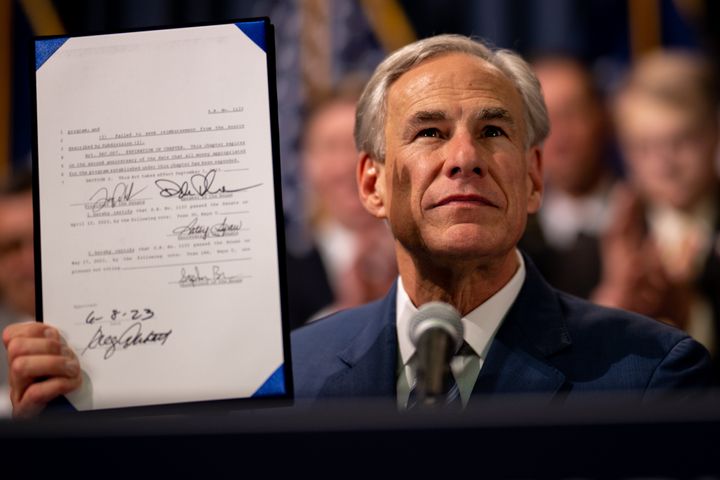 Texas Gov. Greg Abbott displays a bill he signed at a news conference on June 8 in Austin, Texas. Abbott said the new physical obstacles on the border were meant to keep migrants from even reaching Texas' border.