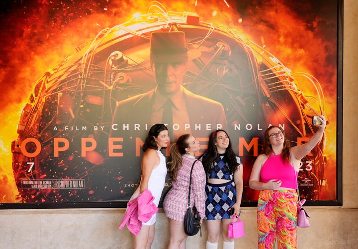 From left, Gabrielle Roitman, Kayla Seffing, Maddy Hiller and Casey Myer take a selfie in front of an "Oppenheimer" movie poster before they attended an advance screening of "Barbie" on Thursday in Los Angeles.