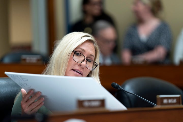 Rep. Marjorie Taylor-Greene (R-Ga.) prepares to hold up explicit images and an airline confirmation made by Hunter Biden during a House Oversight and Accountability Committee hearing on Wednesday. Hunter Biden's attorney has since called on the Office of Congressional Ethics to “promptly and decisively condemn and discipline” Greene over the naked picture showcase.