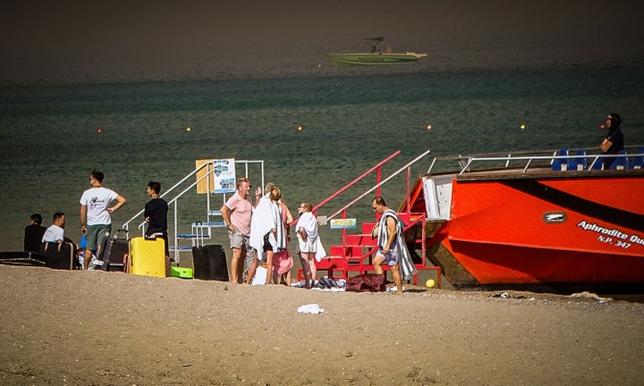 Tourists are evacuated by boat from a beach in the village of Kiotari on the Greek island of Rhodes during a wild fire on July 22, 2023. Three coastguard boats were leading more than 20 vessels in an emergency evacuation effort to rescue people from the Greek island, where fire has been raging out of control for five days. (Photo by EUROKINISSI / Eurokinissi / AFP) (Photo by EUROKINISSI/Eurokinissi/AFP via Getty Images)