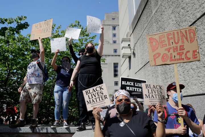 Demonstrators hold signs outside the City Justice Center, Monday, June 1, 2020, in St. Louis. Protesters gathered to speak out against the death of George Floyd who died after being restrained by Minneapolis police officers on May 25. (AP Photo/Jeff Roberson)