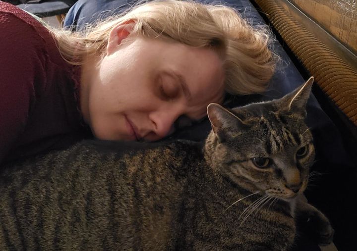 The author rests with her cat Star in July 2020. "Frequent rest is essential for many people with long COVID," she writes.