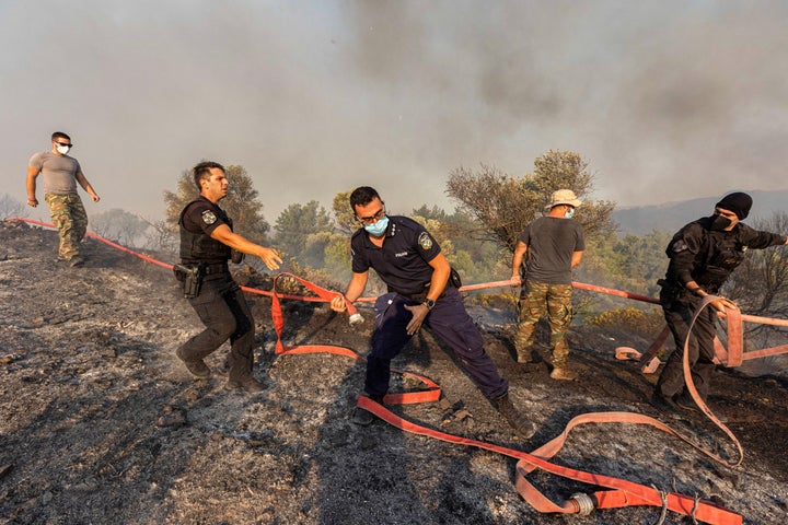 Firefighters, volunteers and police officers operate as a wildfire burns near the village of Asklipieio, on the island of Rhodes, Greece, on July 24, 2023.