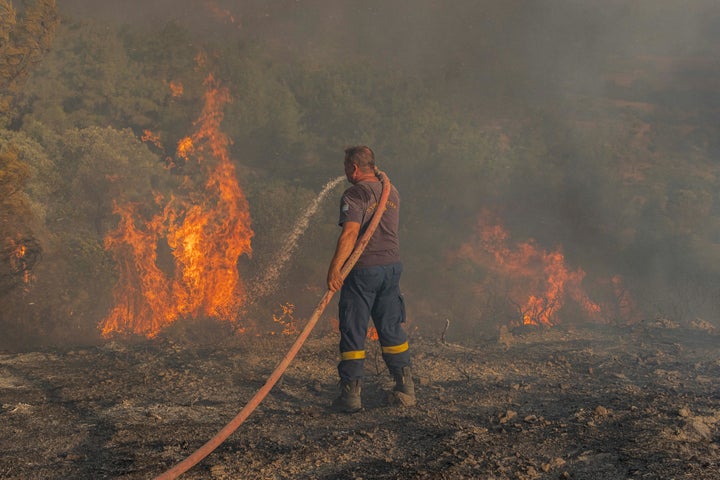 Firefighter Nektarios Kefalas tries to extinguish a wildfire burning near the village of Asklipieio, on the island of Rhodes, Greece, on July 24, 2023.