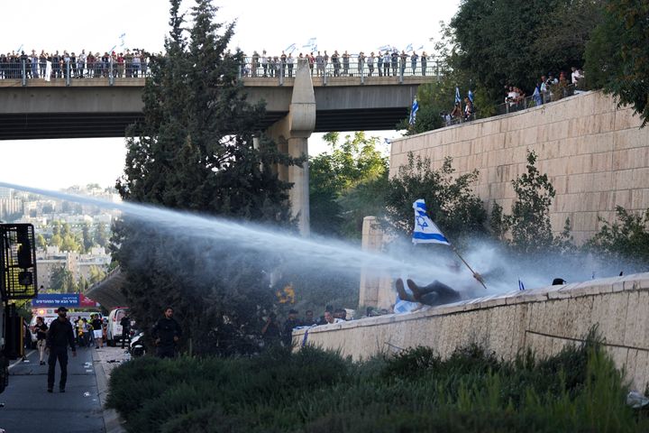 Israeli police use a water cannon to disperse demonstrators blocking a road during a protest against plans by Prime Minister Benjamin Netanyahu's government to overhaul the judicial system, in Jerusalem, Monday, July 24, 2023. Israeli lawmakers on Monday approved a key portion of Prime Minister Benjamin Netanyahu's divisive plan to reshape the country's justice system despite massive protests that have exposed unprecedented fissures in Israeli society. (AP Photo/Ohad Zwigenberg)