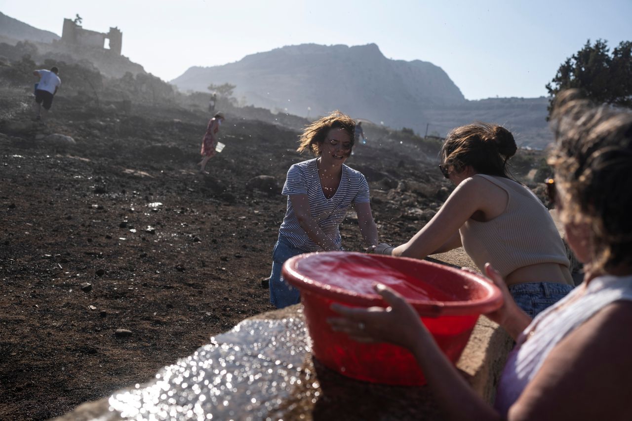 Γερμανοί τουρίστες μαζί με ντόπιους γεμίζουν λεκάνες με νερό για να σβήσουν εστίες φωτιάς 