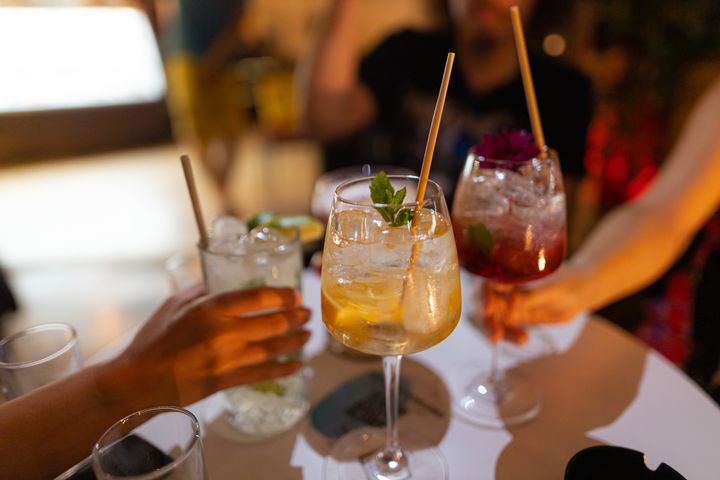 A shot of a group of people at a restaurant having a cocktail drink at night, celebrating, and having fun.