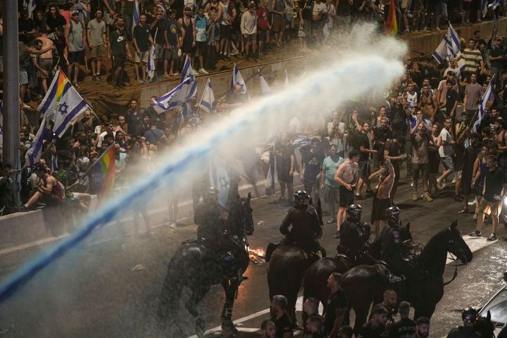 Riot police tries to clear demonstrators with a water cannon during a protest against plans by Netanyahu's government to overhaul the judicial system, in Tel Aviv, on July 24, 2023.