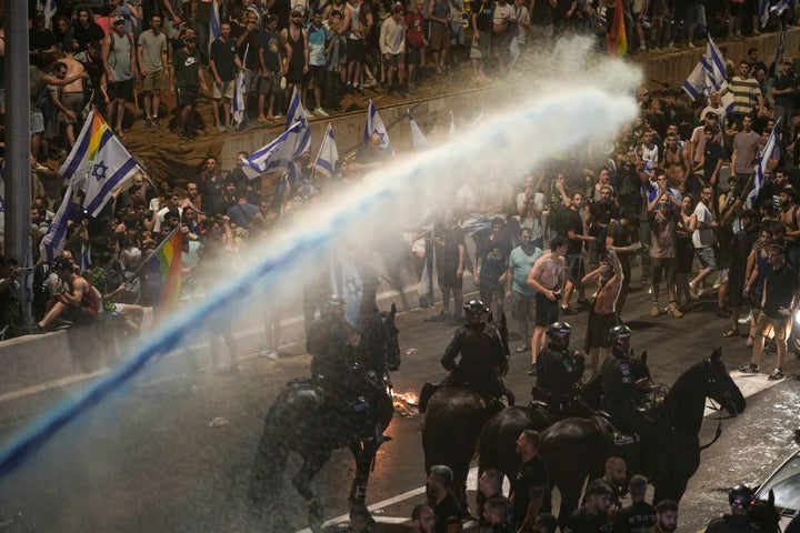 Riot police tries to clear demonstrators with a water cannon during a protest against plans by Netanyahu's government to overhaul the judicial system, in Tel Aviv, on July 24, 2023.