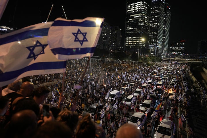 Demonstrators block the traffic on a highway crossing the city during a protest against plans by Netanyahu's government to overhaul the judicial system, in Tel Aviv, on July 24, 2023.