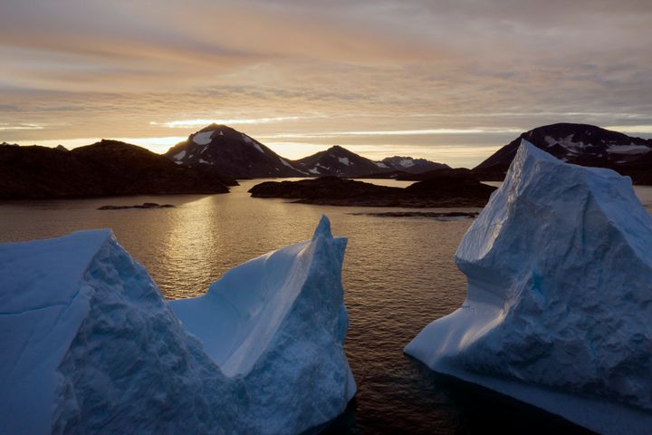 Large Icebergs floating as the sun rises near Kulusuk, Greenland.