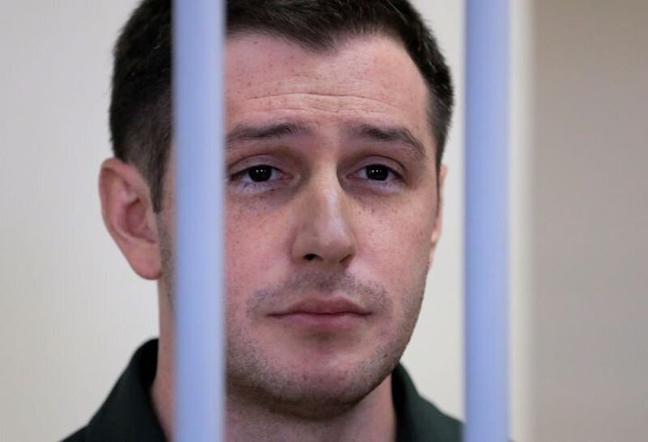 U.S. ex-Marine Trevor Reed, who was detained in 2019 and accused of assaulting police officers, stands inside a defendants' cage during a court hearing in Moscow, Russia, on March 11, 2020. 