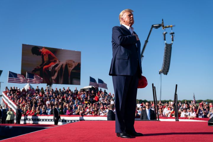 FILE - Former President Donald Trump stands while a song, "Justice for All," is played during a campaign rally at Waco Regional Airport, March 25, 2023, in Waco, Texas. The song features a choir of men imprisoned for their role in the Jan. 6, 2021, insurrection at the U.S. Capitol singing the national anthem and a recording of Trump reciting the Pledge of Allegiance. (AP Photo/Evan Vucci)