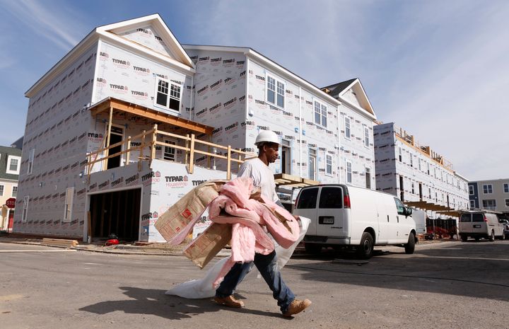 A worker carries insulation at a new housing construction site in Alexandria, Virginia, in 2012