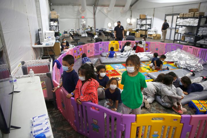 Unaccompanied migrant minors, aged 3 to 9, watch a television monitor inside a playpen at a U.S. Customs and Border Protection facility in Donna, Texas, in 2021.