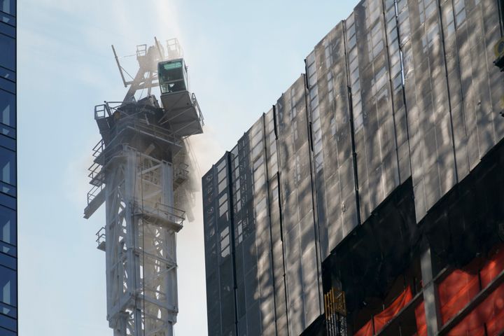 Smoke rises from a construction crane that caught fire in Manhattan on Wednesday. The crane lost its long arm, which smashed against a nearby building, dangled and then plummeted to the street as people ran for their lives on the sidewalk below. Some people suffered minor injuries, but no one died, according to Mayor Eric Adams.
