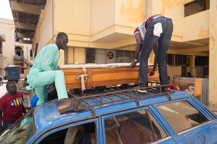 Άνθρωποι μετακινούν το φέρετρο του φίλου τους Αμπντού Ντίοπ, ο οποίος πέθανε προσπαθώντας να μεταναστεύσει στην Ευρώπη, στο νεκροτομείο του Σαιντ- Λούις της Σενεγάλης,(15/72023).