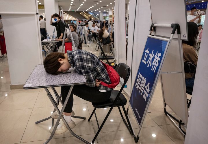Μια κοπέλα αναπαύεται σε ένα τραπέζι σε μια έκθεση εργασίας στο Πεκίνο της Κίνας, στον αγώνα εύρεσης εργασίας τη στιγμή που η ανεργία των νέων στη χώρα βρίσκεται σε επίπεδα ρεκόρ. 