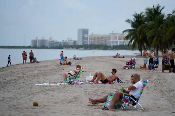 Beachgoers lounge in Crandon Park, Friday, July 28, 2023, in Key Biscayne, Florida.