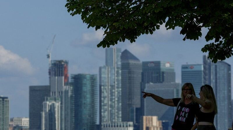 two women standing in front canary wharf in london