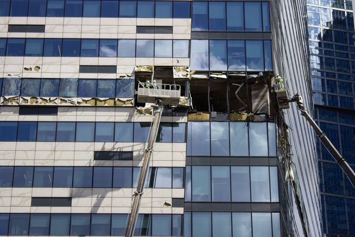 City workers use cranes to clean up the debris at the sight of another explosion in the Moscow City business centre.