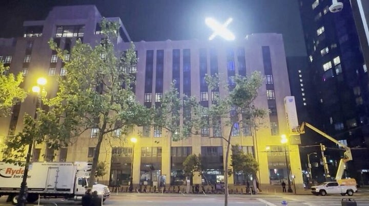 A crew works to remove the Twitter sign as an illuminated 'X' logo is seen on top of the building in San Francisco, California, US, July 29, 2023.