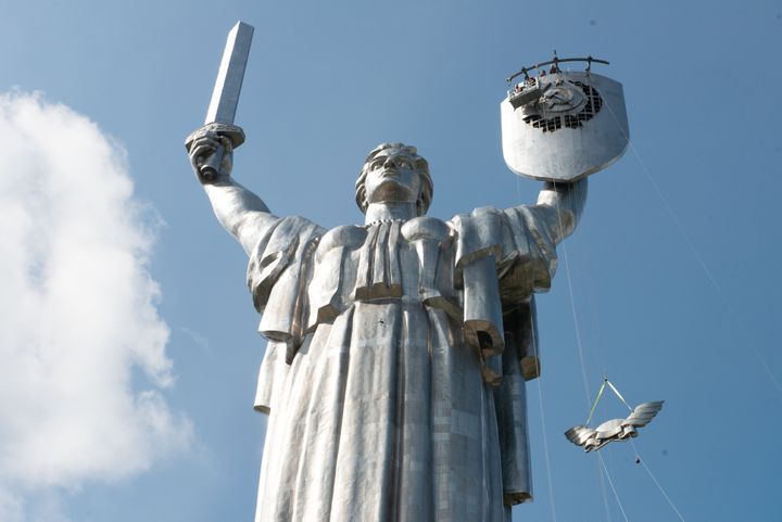 Steeplejacks dismantle a part of the Soviet shield from the Motherland monument on August 1, 2023 in Kyiv, Ukraine.
