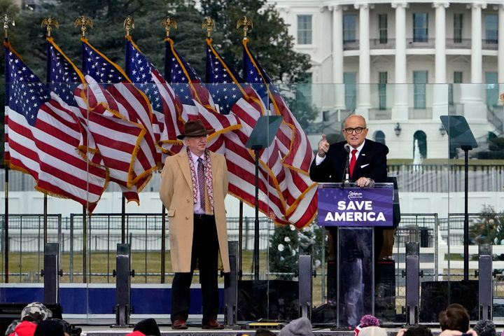 Chapman University law professor John Eastman stands at left as former New York Mayor Rudy Giuliani speaks at the rally that preceded the Jan. 6, 2021, insurrection.