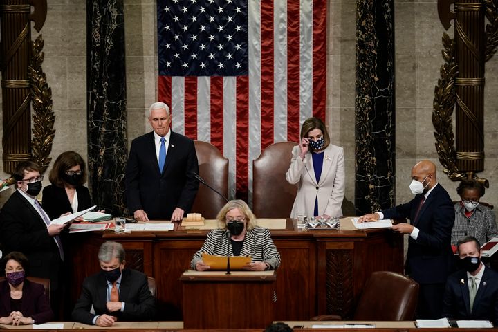 Vice President Mike Pence and Speaker of the House Nancy Pelosi (D-Calif.) read the final certification of Electoral College votes cast in the 2020 presidential election at the Capitol on Jan. 7, 2021, hours after the congressional session was halted by rioting Trump supporters.