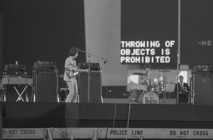 At a Beatles concert at New York City's Shea Stadium in the 1960s, signs admonished the assembled Beatlemaniacs not to throw objects or cross the police line.