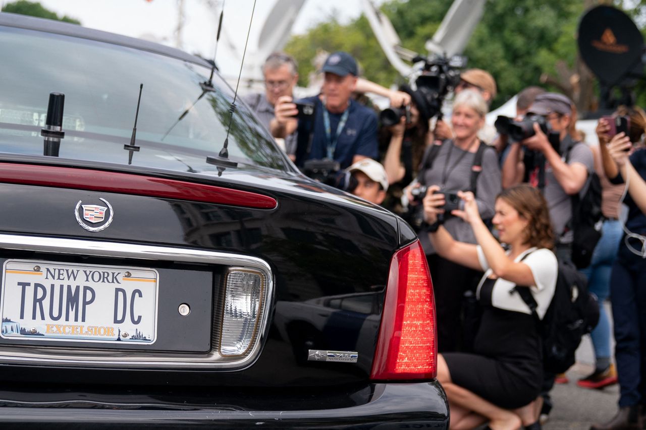 Members of the media surround a replica of the presidential limousine outside the E. Barrett Prettyman U.S. Courthouse.