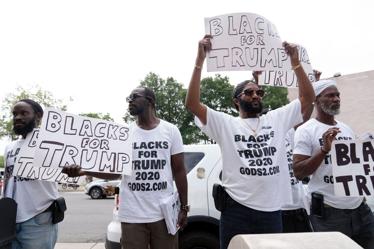 Supporters of Trump hold their banners before his arrival at court.