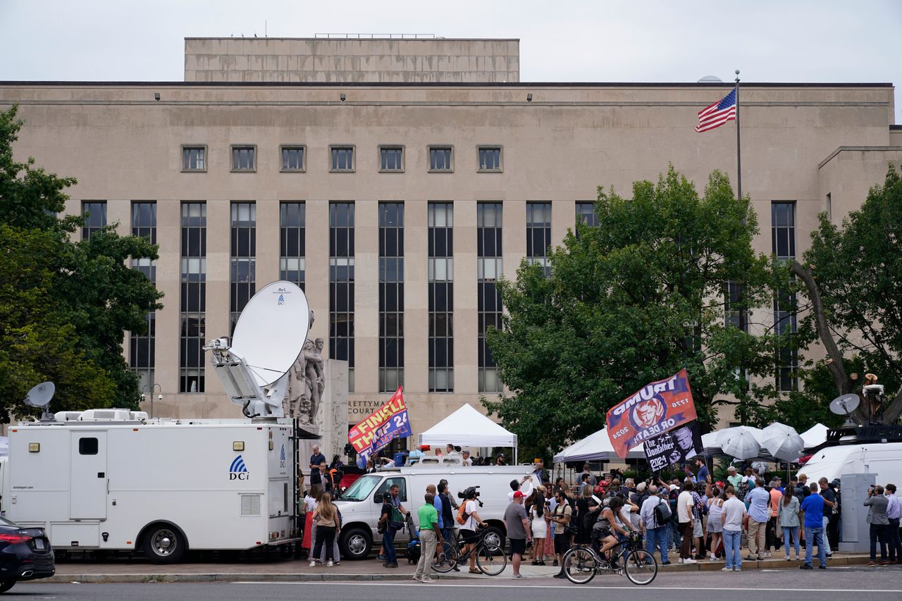 Media and protesters gather at the E. Barrett Prettyman U.S. Courthouse.