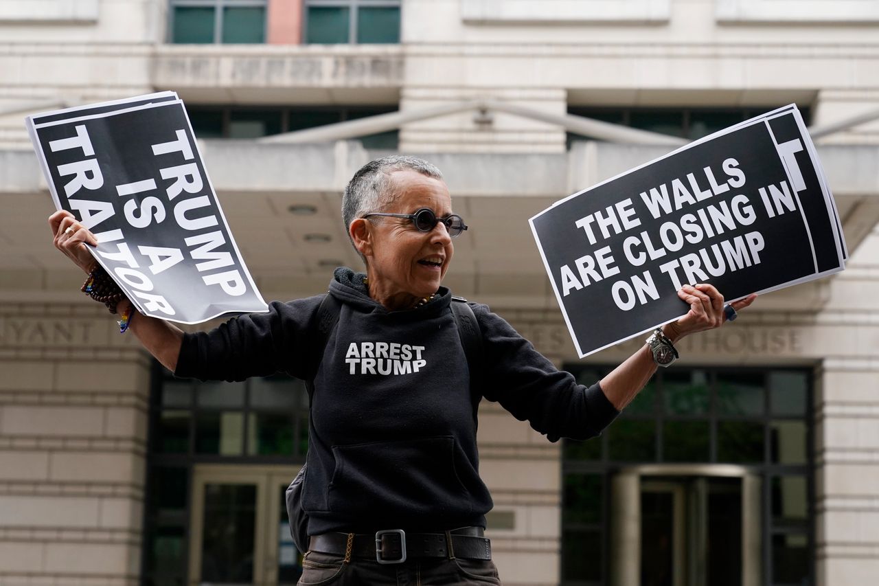 Laurie Arbeiter of New York holds protest signs outside the courthouse.