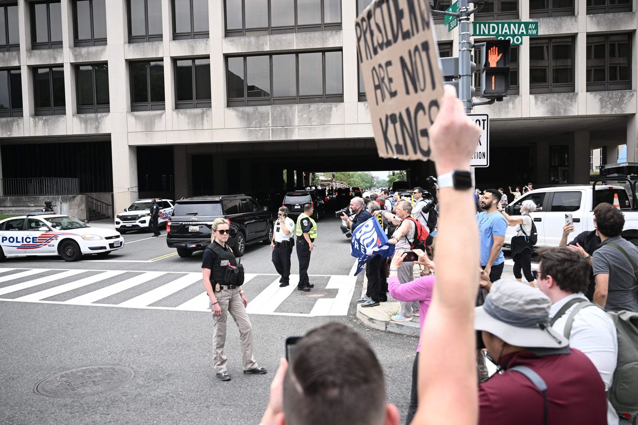 A protester holds a sign near the courthouse shortly before Trump's arrival.