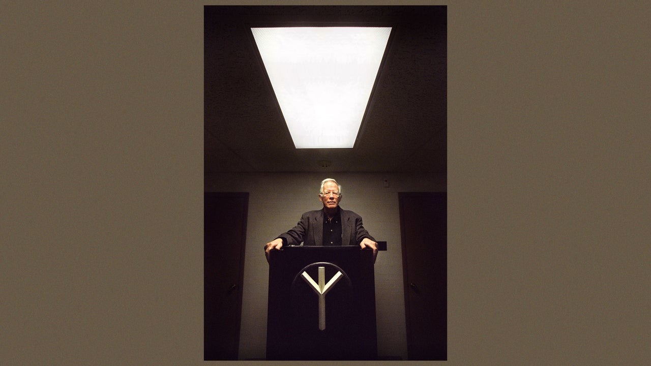 In this 2000 photo, William Pierce stands at a lectern with the symbol for the National Alliance, the neo-Nazi group he founded.