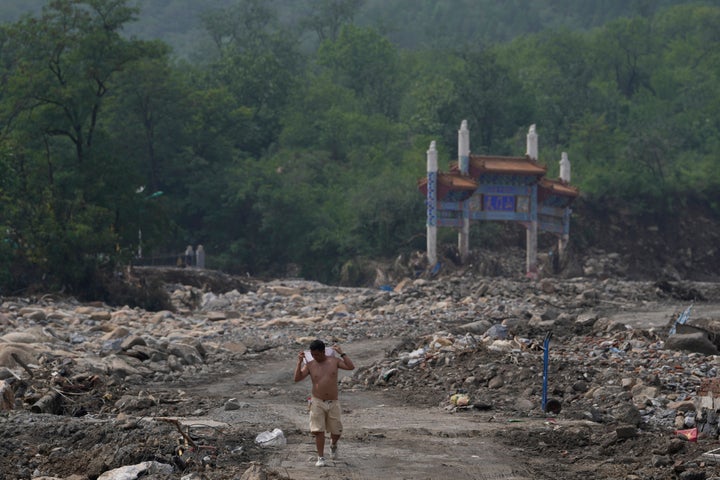 A man walks near a gate way near the flood devastated Nanxinfang village on the outskirts of Beijing, Friday, Aug. 4, 2023. Heavy rain and high water levels on rivers in northeastern China were threatening cities downstream on Friday, prompting the evacuation of thousands, although the country appears to have averted the worst effects of the typhoon season battering parts of east Asia. (AP Photo/Ng Han Guan)