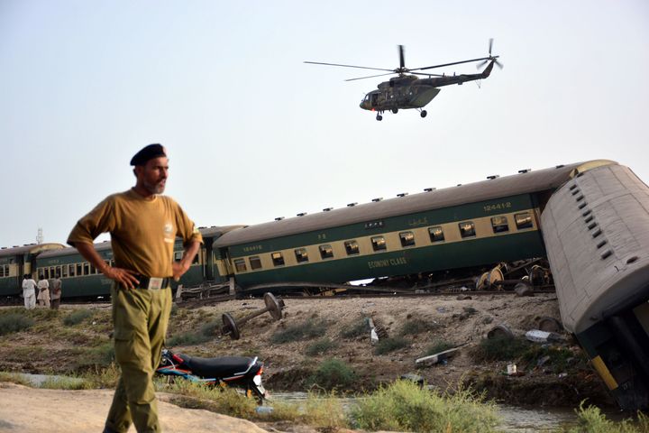 A helicopter monitors the area after an express train derails in Nawabshah, Pakistan, on August 06, 2023. At least 30 people have been killed and 90 injured when a train derailed in southern Pakistan. Several carriages of the Hazara Express overturned near Sahara railway station in Nawabshah.
