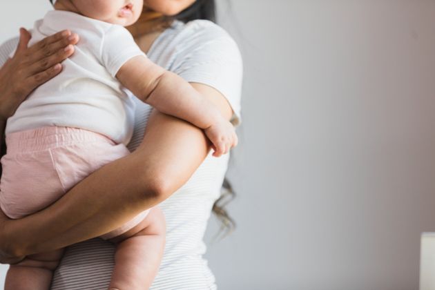 An unrecognizable new mother comforts her unrecognizable baby girl.