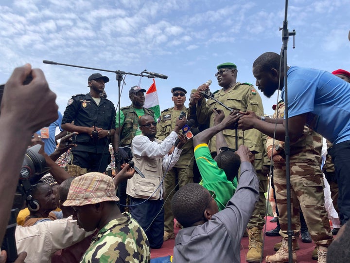Supporters of Niger's ruling junta, accompanied by some security forces, stand guard at a roundabout in Niamey, Niger, on Aug. 6, 2023, checking cars for weapons and keeping an eye out for foreign intervention.